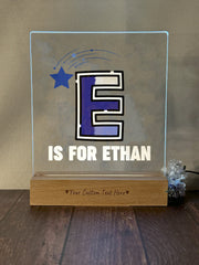 a glass plaque with the letter e is for ethan