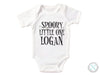 a white bodysuit that says spooky little one logan