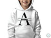 a young boy wearing a white hoodie with the letter a on it