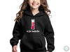 a little girl wearing a black hoodie with a red liquid in it